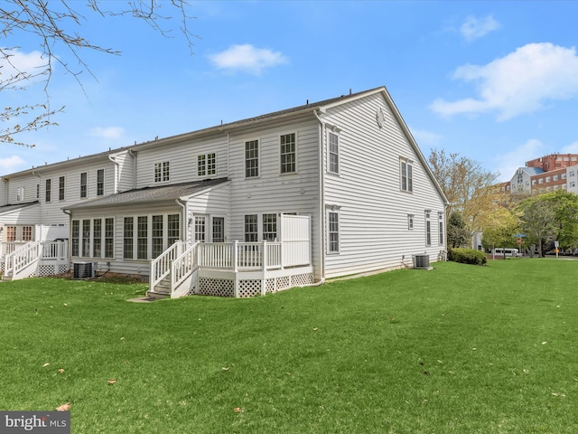 rear view of property featuring central air condition unit, a lawn, and a deck