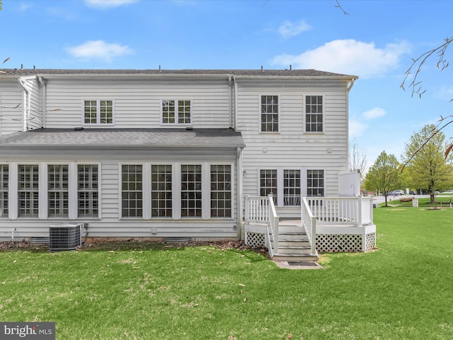 rear view of property featuring a lawn, central AC unit, and a wooden deck