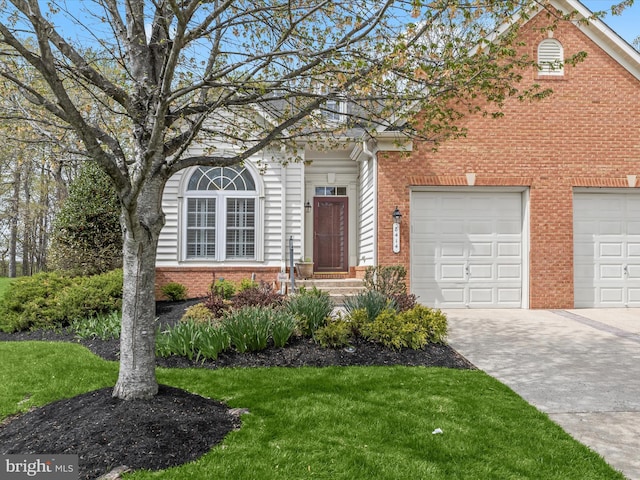 view of front of property with a front lawn, driveway, brick siding, and a garage