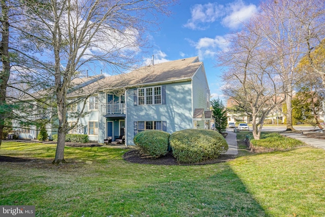 view of front of home with a front yard and a balcony