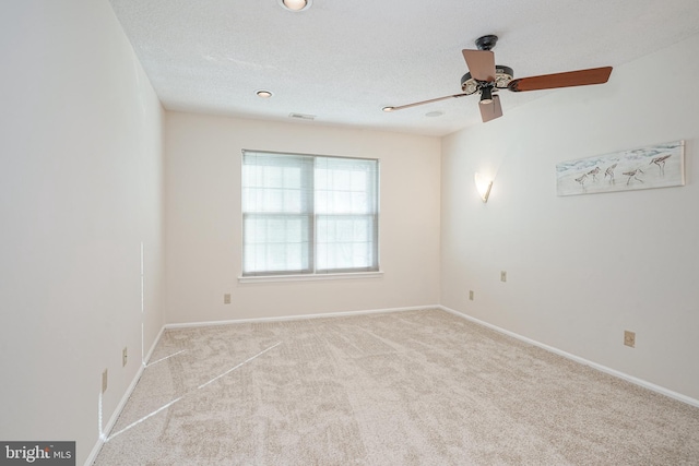 carpeted spare room featuring a textured ceiling and ceiling fan