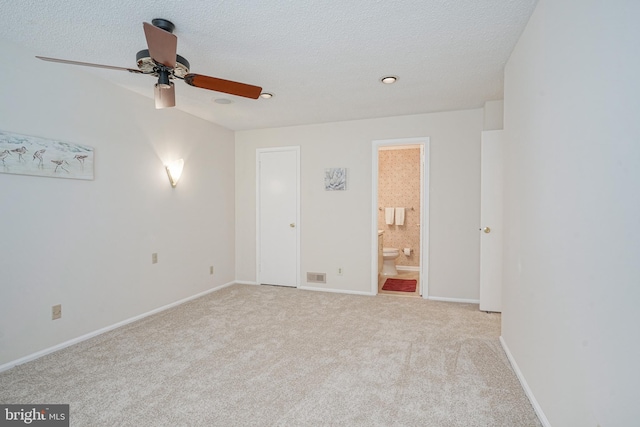 carpeted spare room with a textured ceiling and ceiling fan