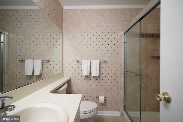 bathroom featuring toilet, vanity, tile patterned floors, ornamental molding, and a shower with door