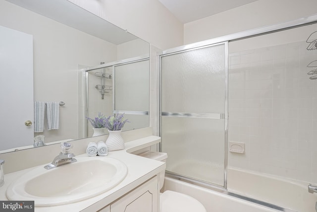 full bathroom featuring toilet, vanity, and combined bath / shower with glass door