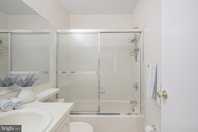 full bathroom featuring toilet, enclosed tub / shower combo, and vanity