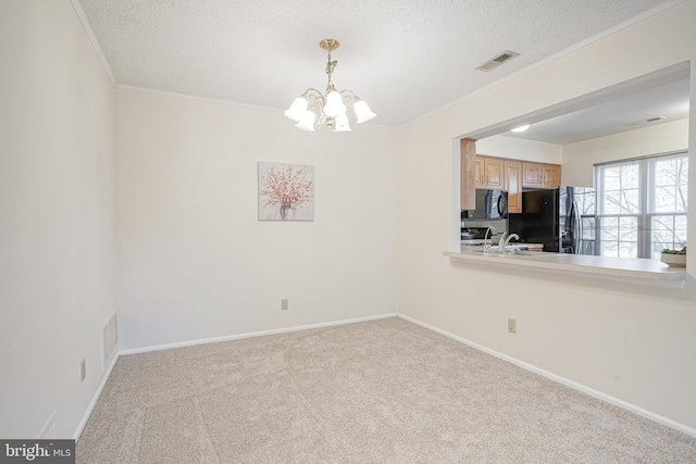 empty room with sink, an inviting chandelier, a textured ceiling, light carpet, and crown molding