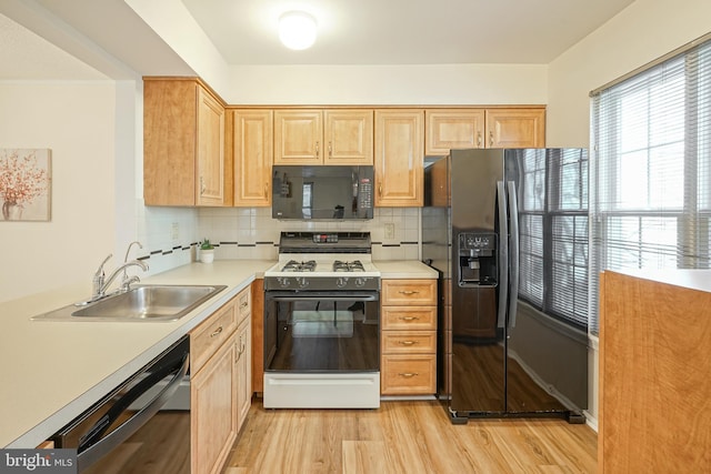 kitchen with sink, black appliances, decorative backsplash, light wood-type flooring, and light brown cabinets