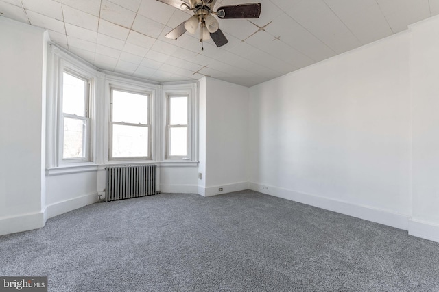 spare room with ornamental molding, carpet floors, ceiling fan, and radiator heating unit