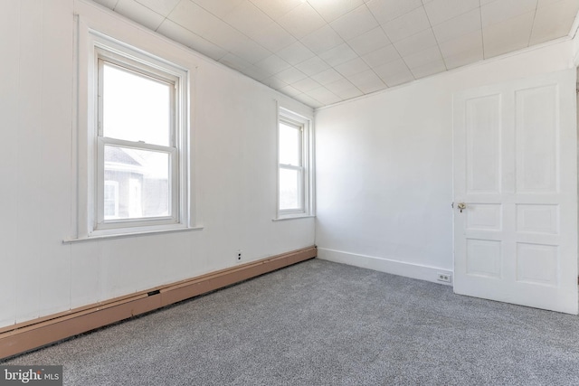 unfurnished room with baseboard heating and carpet