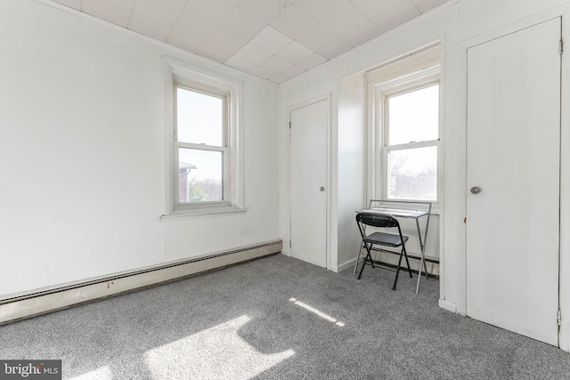 unfurnished bedroom featuring dark carpet and a baseboard heating unit