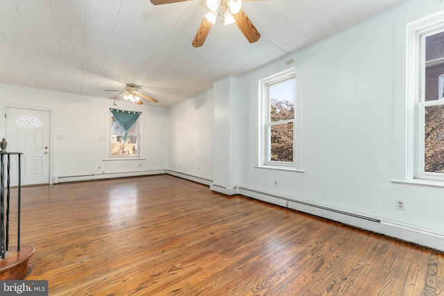 empty room with hardwood / wood-style floors and a baseboard heating unit