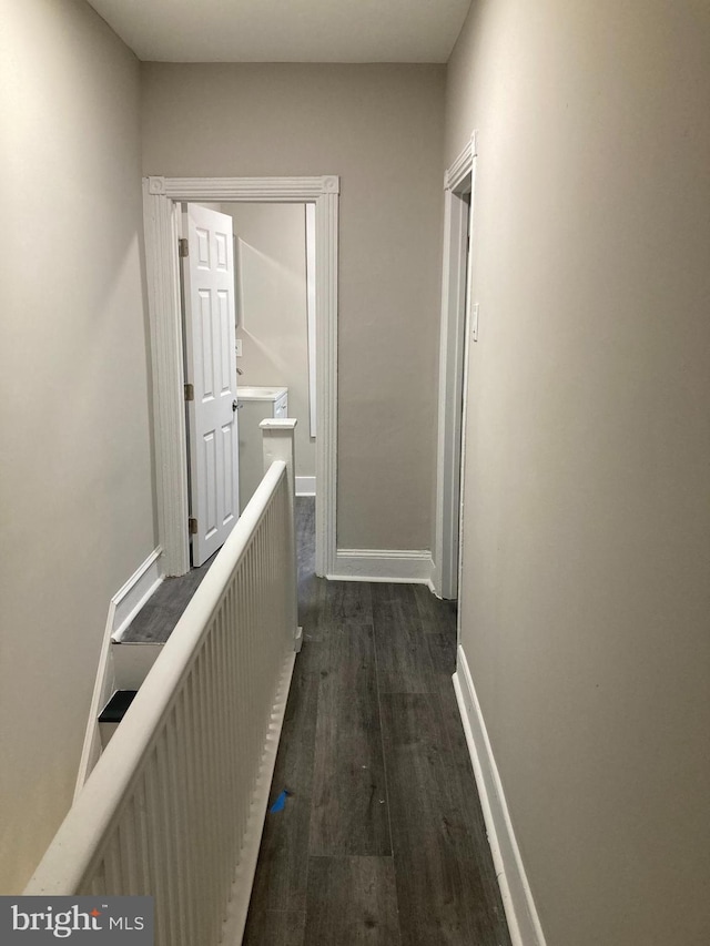 corridor with dark hardwood / wood-style flooring