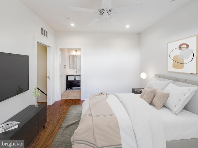 bedroom with dark hardwood / wood-style floors, ceiling fan, and ensuite bath