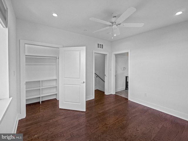 unfurnished bedroom featuring dark wood-type flooring, ceiling fan, and a closet