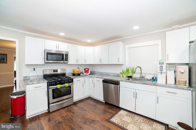 kitchen featuring white cabinets, appliances with stainless steel finishes, light stone countertops, and sink