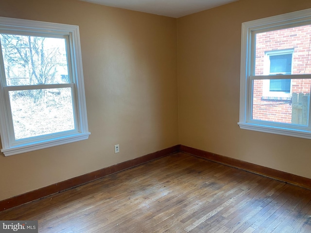 empty room with baseboards and hardwood / wood-style floors