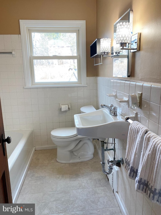 full bath featuring toilet, a sink, a bathing tub, radiator heating unit, and tile walls