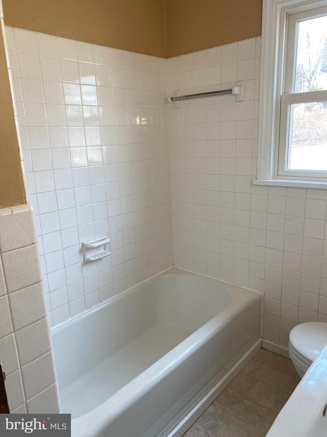 full bathroom with toilet, tile walls, a bath, and a shower