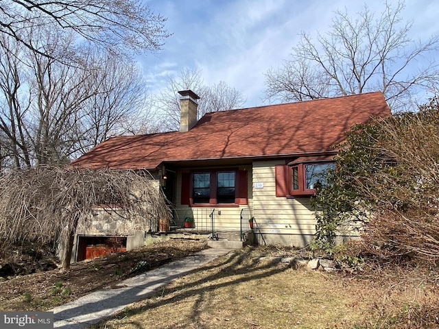 view of front of property with a chimney and a shingled roof