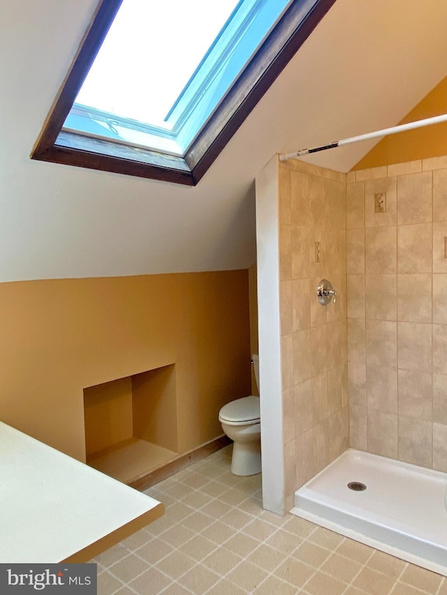 full bathroom with lofted ceiling with skylight, toilet, and tiled shower