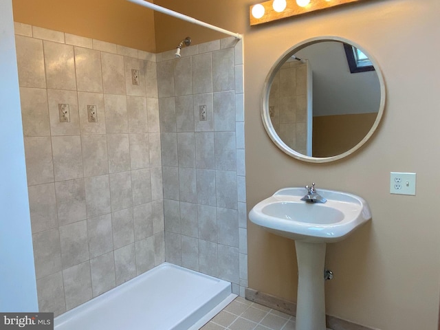 bathroom with a tile shower and tile patterned floors