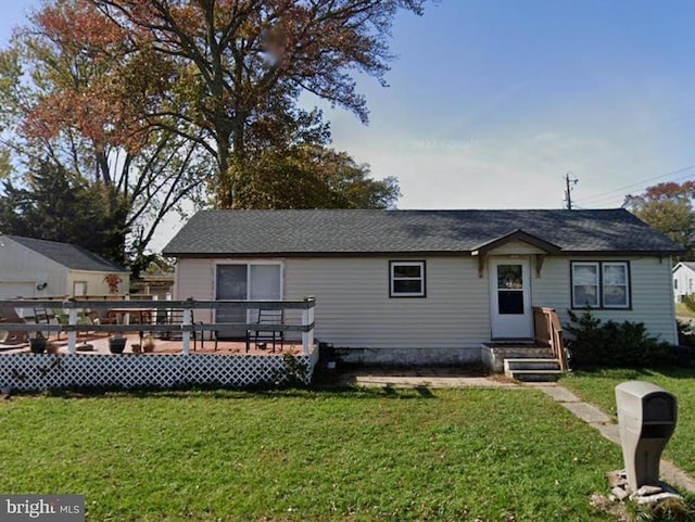 view of front of house with a wooden deck and a front lawn