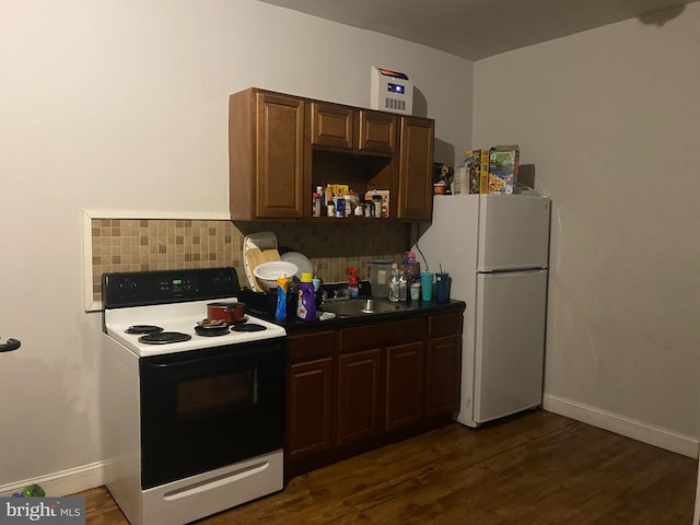 kitchen featuring decorative backsplash, dark brown cabinets, white appliances, sink, and dark hardwood / wood-style floors