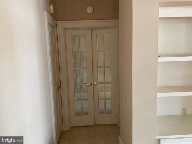 hallway with light tile patterned floors and french doors