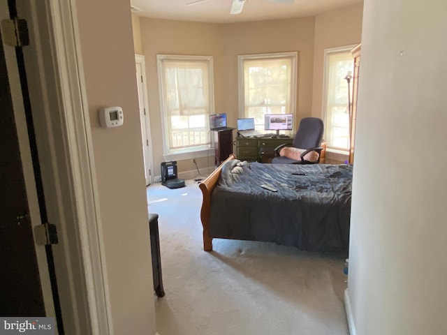 bedroom with ceiling fan and light carpet