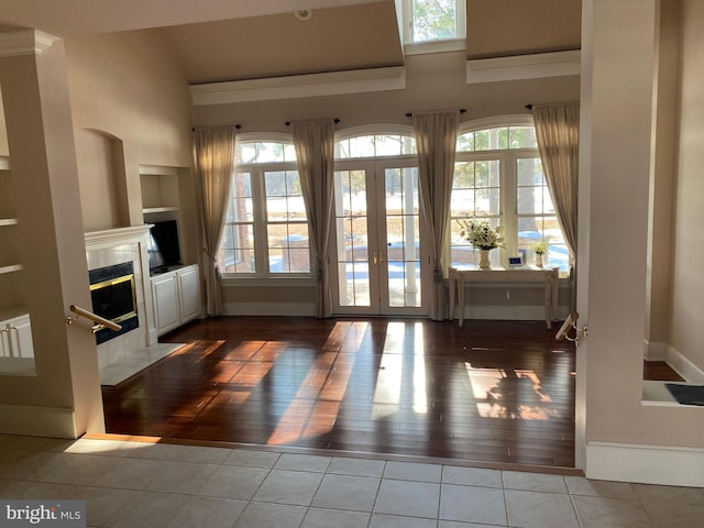 doorway to outside featuring tile patterned floors, built in shelves, french doors, and a high end fireplace