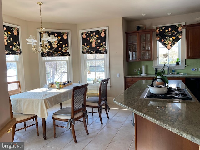 tiled dining room with a notable chandelier and sink