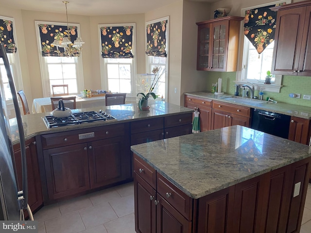 kitchen featuring a center island, stainless steel gas cooktop, a healthy amount of sunlight, decorative light fixtures, and black dishwasher