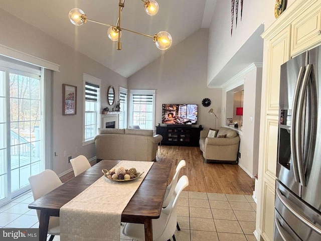 dining space featuring light tile patterned floors and vaulted ceiling