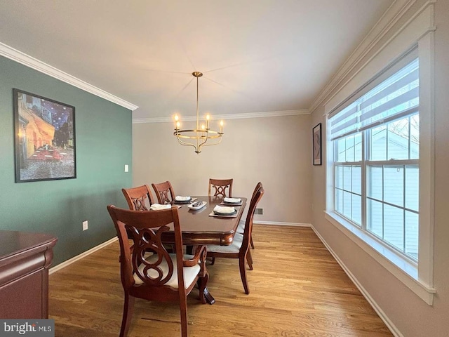 dining area featuring hardwood / wood-style floors, a notable chandelier, and crown molding