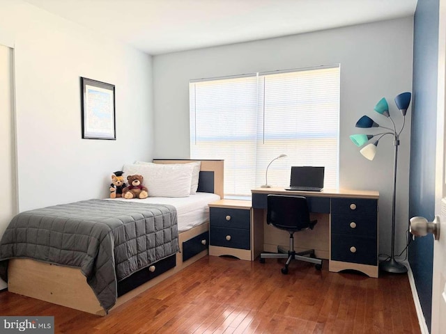 bedroom with dark hardwood / wood-style flooring and multiple windows