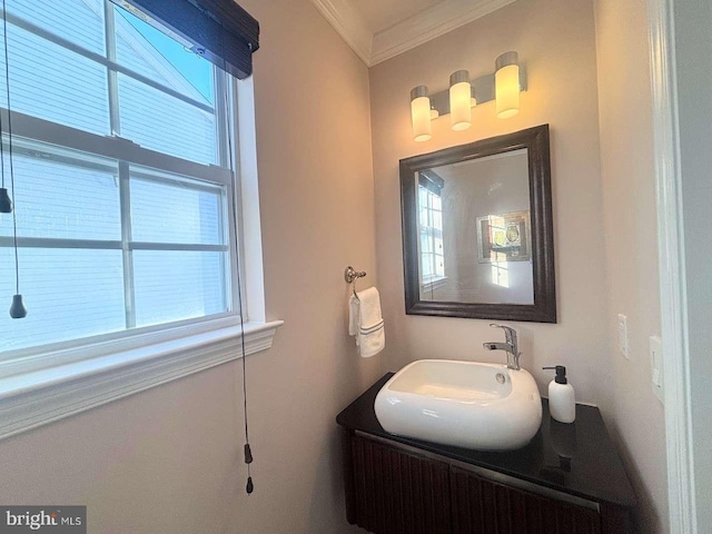 bathroom with a healthy amount of sunlight, vanity, and ornamental molding