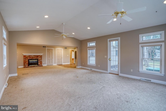 unfurnished living room featuring light carpet, a fireplace, vaulted ceiling, and ceiling fan