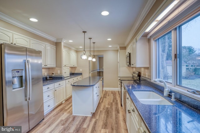 kitchen featuring appliances with stainless steel finishes, decorative light fixtures, sink, dark stone counters, and ornamental molding