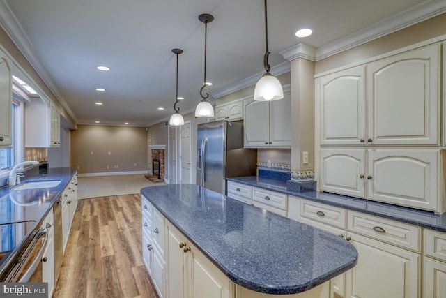 kitchen with a kitchen island, pendant lighting, sink, ornamental molding, and stainless steel refrigerator with ice dispenser