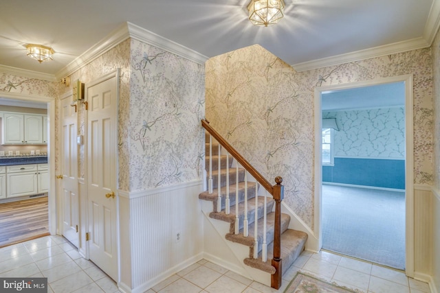 staircase featuring tile patterned floors and ornamental molding