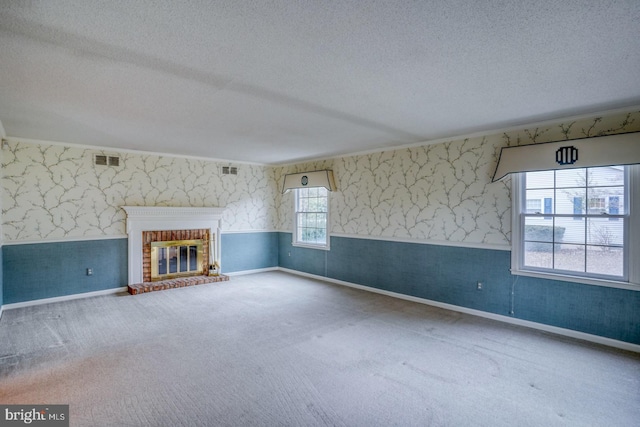 unfurnished living room with a fireplace, carpet flooring, and a textured ceiling