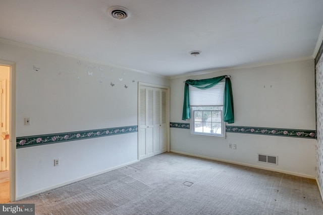 carpeted spare room featuring crown molding