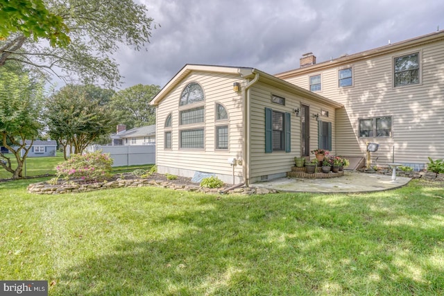 view of side of property with a yard and a patio area