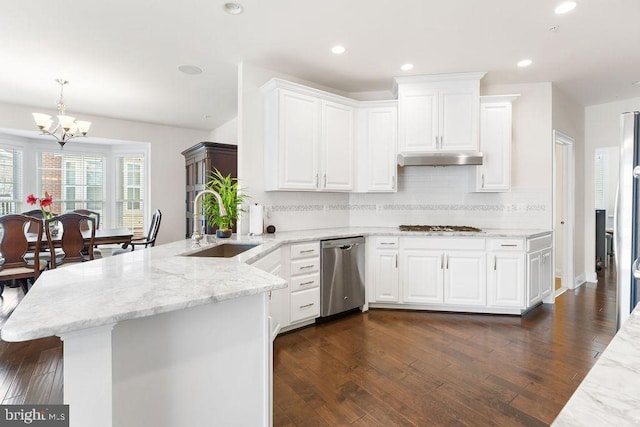 kitchen featuring kitchen peninsula, white cabinets, stainless steel appliances, and a notable chandelier