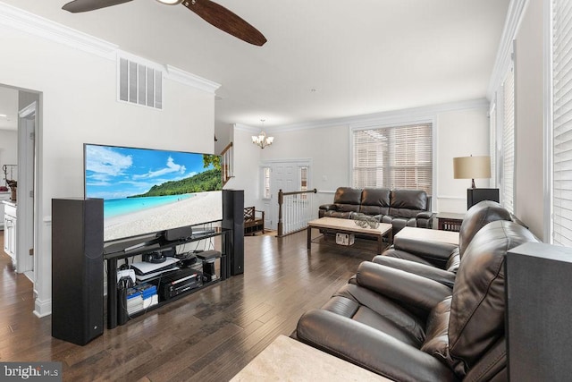 living room featuring dark hardwood / wood-style floors, crown molding, and ceiling fan with notable chandelier