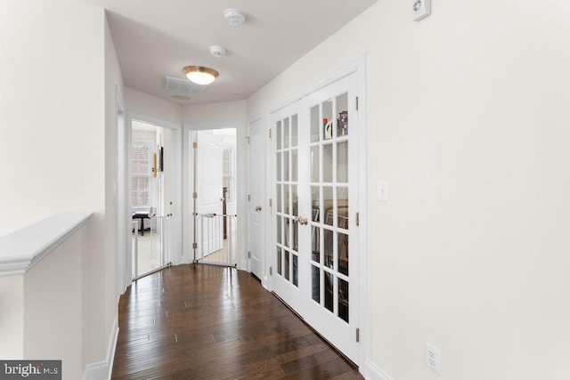 corridor featuring dark wood-type flooring and french doors