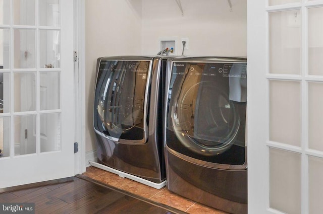 clothes washing area featuring washing machine and clothes dryer and dark wood-type flooring