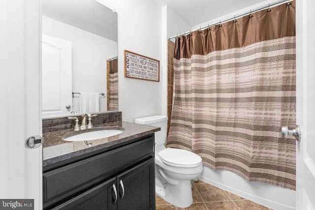 bathroom with toilet, vanity, and tile patterned floors