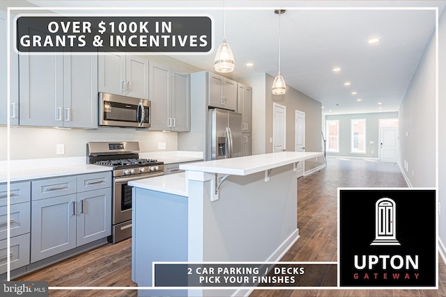 kitchen featuring stainless steel appliances, dark wood-type flooring, gray cabinets, a kitchen island, and hanging light fixtures