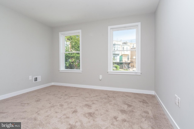 unfurnished room featuring light colored carpet